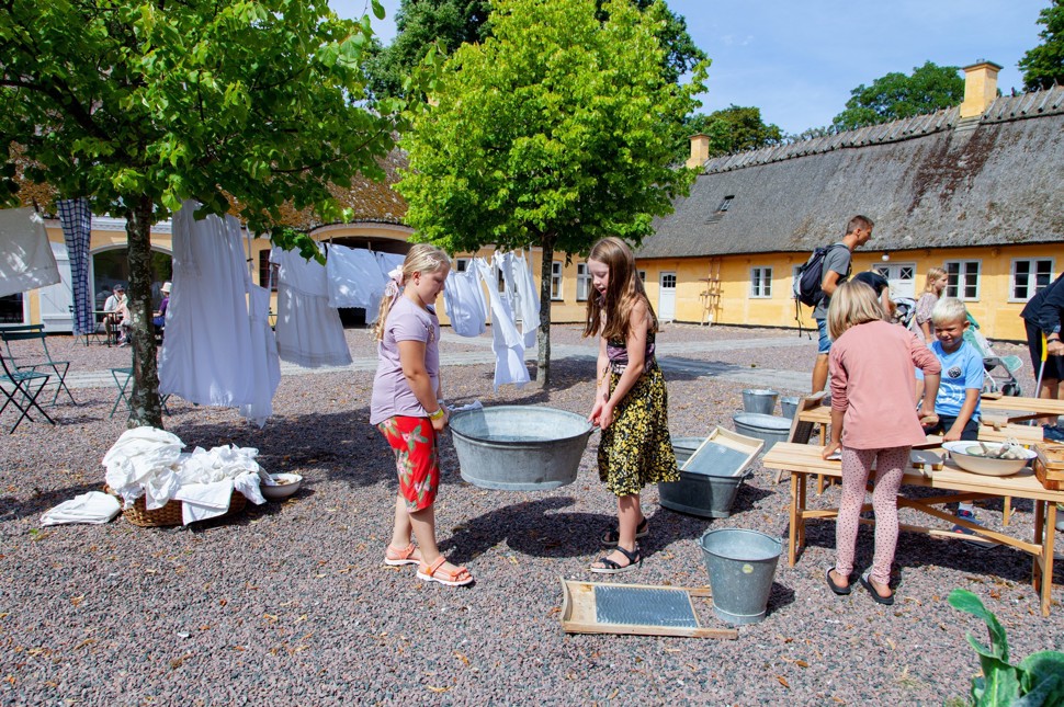 To piger bærer en vaskebalje