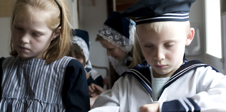 Børn skriver på tavler i skolestuen