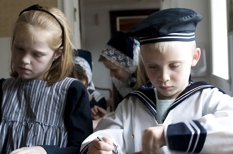Børn skriver på tavler i skolestuen