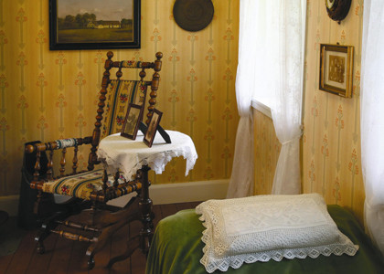 Billede viser en stue fra 1920, hvor datter har ændret på moderens broderede pyntehåndklæde og lavet det til pudebetræk