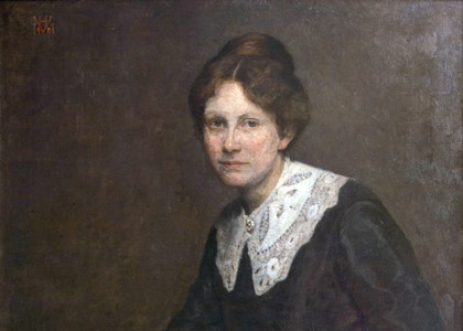 Kvinde i sort kjole udsmykket med Hedebosyet krave og om håndleddene