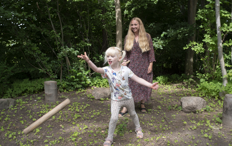 Pige og kvinde leger gammeldags lege på Greve Museum